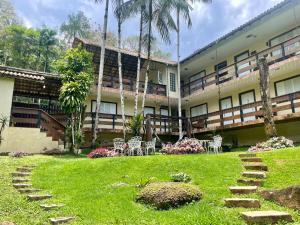 a courtyard of a building with chairs and trees at Flat Salto Dagua Penedo in Penedo