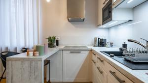 a kitchen with white cabinets and a sink at Mariposa in Lecco