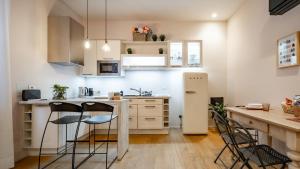 a kitchen with white cabinets and a counter with stools at Mariposa in Lecco