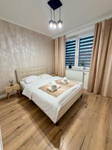 a bedroom with a large white bed and a window at Apartament KJ Tomice in Tomice
