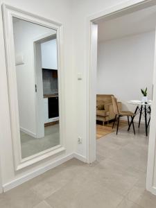a living room with a mirror and a table at Apartament KJ Tomice in Tomice