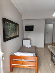 a bedroom with a bed and a painting on the wall at ChristAlex Guesthouse in Himare