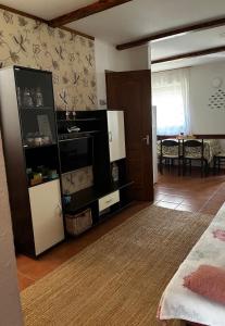 a living room with a large cabinet and a table at Harcsa Vendégház Tiszafüred in Tiszafüred