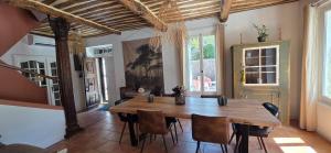 a dining room with a wooden table and chairs at Le MAS CLEMENTINE in Puisserguier