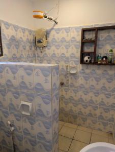 a bathroom with a shower with blue and white patterns at Belle Atelier in Ukunda