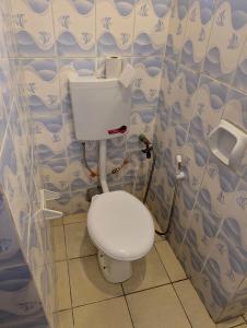 a bathroom with a white toilet in a room at Belle Atelier in Ukunda