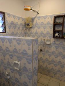 a bathroom with blue and white shower curtains at Belle Atelier in Ukunda