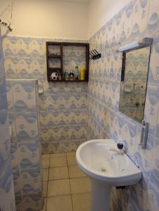 a bathroom with a sink and a mirror at Belle Atelier in Ukunda