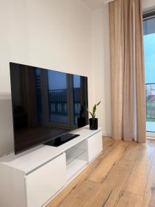 a living room with a large television on a white entertainment center at Apartament KJ Tomice in Tomice +6 photos