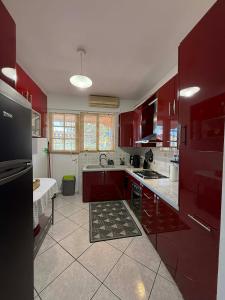 a large kitchen with red cabinets and a sink at Casa Marianna-Luxury Riviera Retreat in Anavyssos