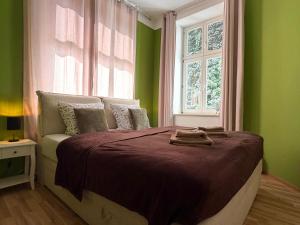 a bedroom with a bed with green walls and a window at Ferienwohnung am Altmarkt, für bis zu 4 Personen, 55qm in Cottbus