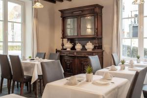 a restaurant with white tables and chairs and windows at Hotel Bryghia in Bruges