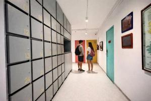 two people standing in a hallway looking at art at Hostal Nube Mia Guadalajara in Guadalajara