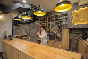 a man standing behind a bar in a restaurant at Prime Heaven in Chiatʼura