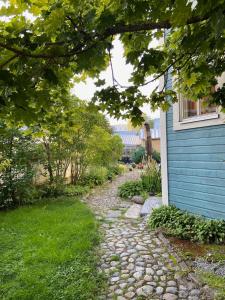 a stone path next to a blue house at Studio Skata in Pietarsaari