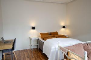 a bedroom with a bed and a desk with two lamps at Studio Skata in Pietarsaari