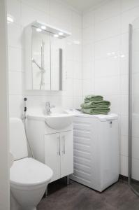 a white bathroom with a toilet and a sink at Studio Skata in Pietarsaari +8 photos