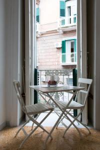 ナポリにあるB&B Cirillo 65のバルコニー付きの客室で、テーブルと椅子2脚が備わります。