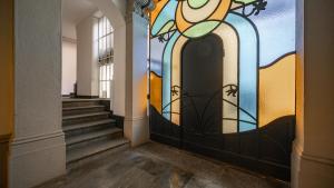 a hallway with a door with a stained glass window at Mariposa in Lecco
