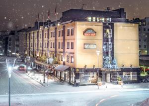 un grand bâtiment dans une rue de la ville dans la neige dans l'établissement Arctic City Hotel, à Rovaniemi