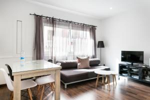 a living room with a couch and a table at Apartamentos Laforja in Barcelona
