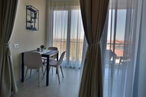 a dining room with a table and chairs and a balcony at Студия Морска хармония in Sozopol +2 photos