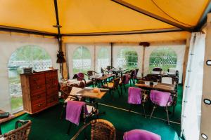 a room filled with tables and chairs with purple chairs at Landhotel Herscheider Mühle in Herscheid