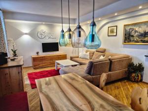 a living room with a couch and a tv at Gästehaus Watzmannblick in Bischofswiesen