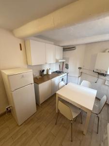 a kitchen with a table and a white refrigerator at Alba in Mele