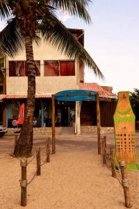 a building with a palm tree in front of a building at Pousada Recanto Paradise in Porto De Galinhas