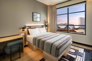 a bedroom with a bed and a desk and a window at Moxy Atlanta Downtown in Atlanta