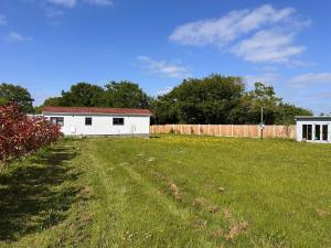 a yard with a white building and a fence at Toad Hall Suite in Chelmsford