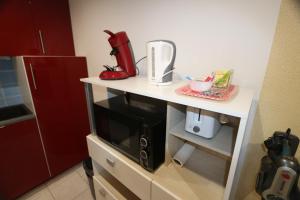 a kitchen counter with a coffee maker and a microwave at Appart Hotel cholet centre in Cholet