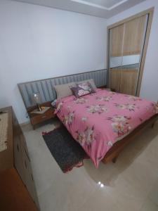 a bedroom with a bed with a pink blanket at hedia a monastir in Monastir