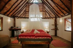 a bedroom with a bed with a mosquito net at Fare Hau Lodge in Tahaa