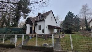 a house that is behind a fence at Harcsa Vendégház Tiszafüred in Tiszafüred