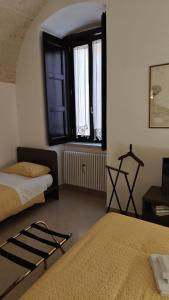 a bedroom with two beds and two windows at Alle volte… in Bisceglie