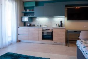 a kitchen with blue cabinets and a stove top oven at Студия Морска хармония in Sozopol