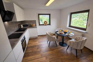 a kitchen and dining room with a table and chairs at MV Römerlodge mit einmaligem Moselpanoramablick in Treis-Karden