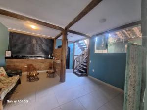 a living room with two chairs and a staircase at Alma Surf House in Boicucanga