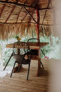 a wooden table with a chair and a table with a plant at Fare Hau Lodge in Tahaa