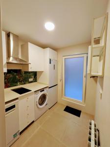 a kitchen with a washing machine and a window at PisoCentro in Santander +2 photos