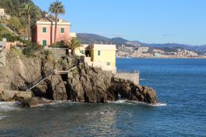a group of buildings on a cliff in the water at Alba in Mele