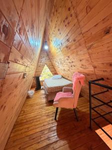 a room with a bed and a chair in a tree house at Cabañas The Twins in Medellín
