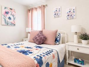 a bedroom with a bed with pink and blue pillows at NEW Beach Cozy Bungalow 2B Mins-beach&downtown in Clearwater