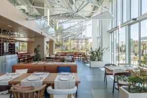 a restaurant with tables and chairs and windows at Nava Star Hotel in Durrës