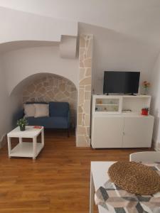 a living room with a couch and a tv at La casetta nel cuore di Sciò in Gioia del Colle