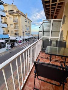 a balcony with tables and chairs on a city street at Rosa Somhome in Peniscola