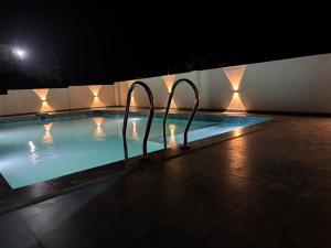 a swimming pool at night with two metal bars in it at Olivet Homestay in Vagamon