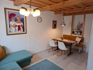 a living room with a table and chairs and a clock at Ferienhaus Weingarten Eisenberg in Vaskeresztes +22 photos
